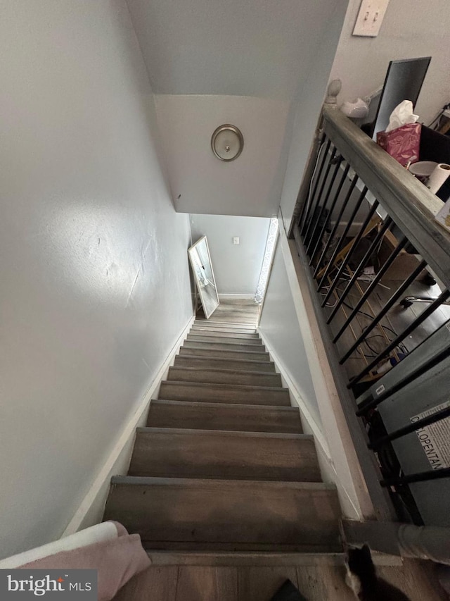 stairway with baseboards and wood finished floors