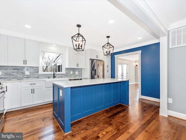 kitchen featuring a kitchen island, light stone countertops, white cabinets, tasteful backsplash, and stainless steel appliances