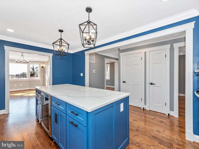 kitchen with wine cooler, a notable chandelier, decorative light fixtures, and blue cabinetry