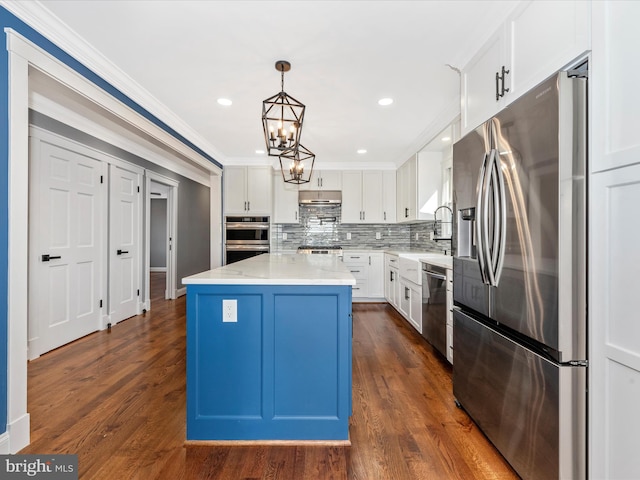 kitchen featuring a center island, a sink, an inviting chandelier, ornamental molding, and stainless steel appliances