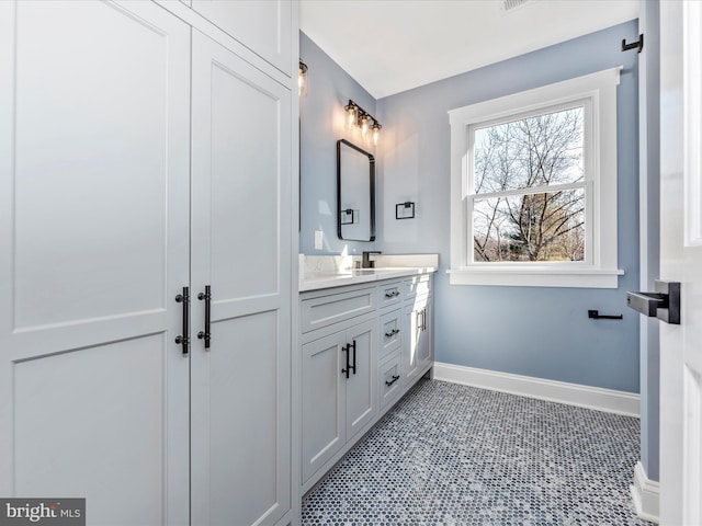 bathroom featuring baseboards, tile patterned floors, and vanity