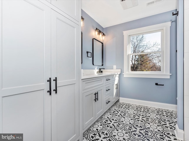 bathroom with baseboards, visible vents, and vanity