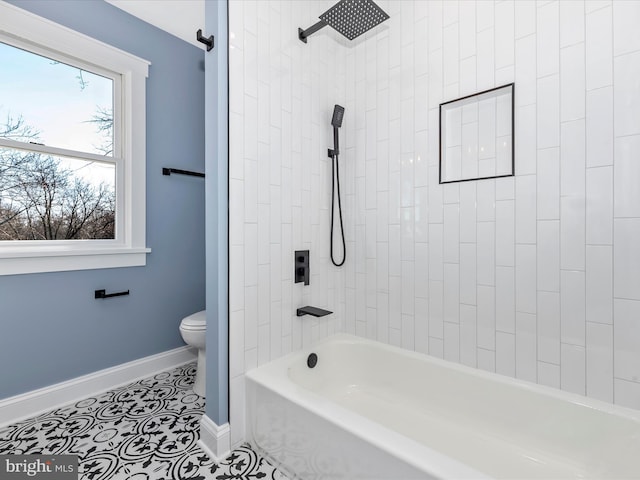 bathroom with toilet, baseboards, washtub / shower combination, and tile patterned floors