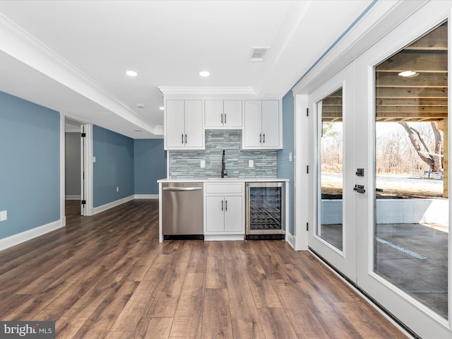 kitchen with beverage cooler, light countertops, tasteful backsplash, a sink, and dishwasher