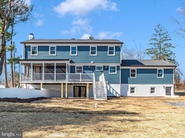 back of property featuring a sunroom, a deck, stairway, a chimney, and french doors