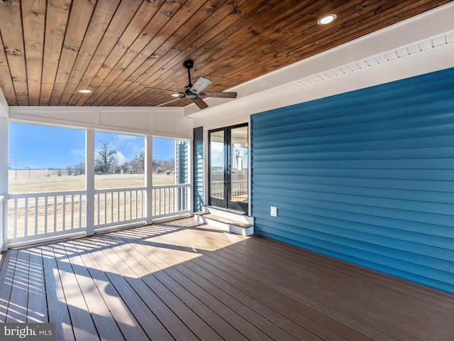 unfurnished sunroom featuring ceiling fan and french doors