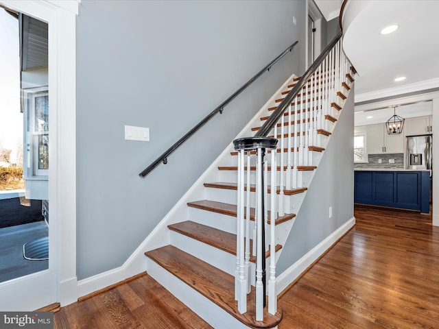 stairs featuring baseboards, ornamental molding, wood finished floors, and recessed lighting