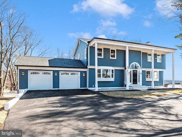 view of front of home featuring a porch, a garage, and driveway