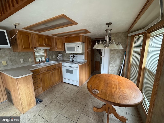 724 Monmouth Rd Unit 38, Cream Ridge, NJ 08514 - kitchen with brown cabinetry, white appliances, light countertops, a sink, and hanging light fixtures