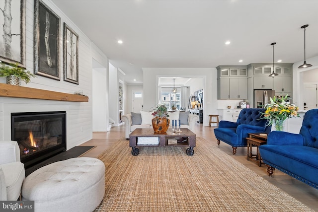 living room featuring recessed lighting, wood finished floors, and a fireplace