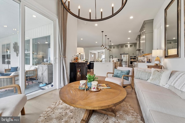 living area with an inviting chandelier, light wood finished floors, and recessed lighting