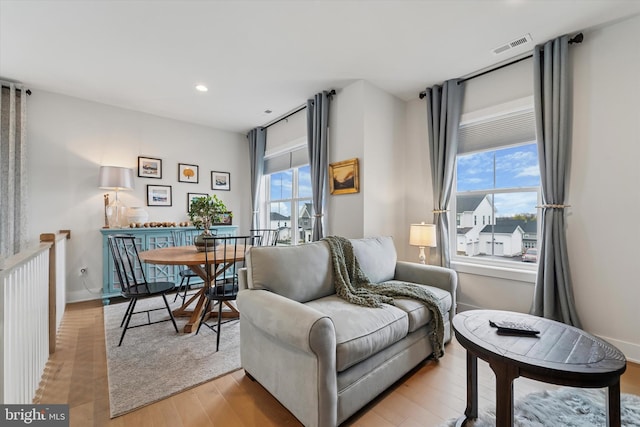 living area featuring light wood-style floors, baseboards, recessed lighting, and visible vents