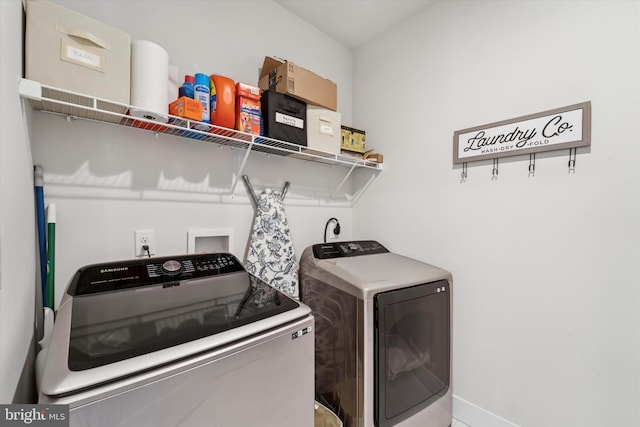 laundry area with baseboards, laundry area, and washer and clothes dryer