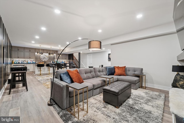 living area with stairs, recessed lighting, baseboards, and light wood-style floors