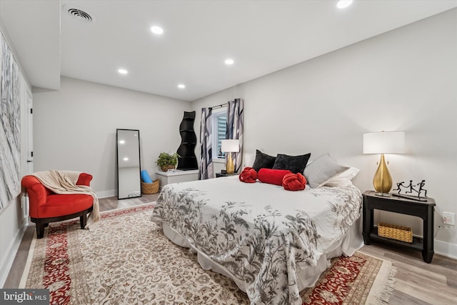 bedroom featuring baseboards, recessed lighting, wood finished floors, and visible vents