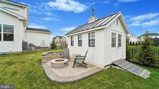 view of outdoor structure featuring an outdoor structure, an outdoor fire pit, and fence