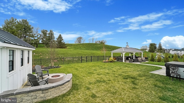 view of yard with a fenced backyard, an outdoor living space with a fire pit, a patio, and a gazebo