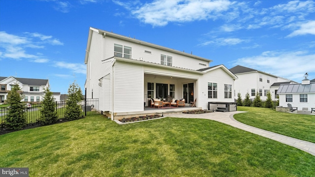 back of house featuring fence, a yard, a patio area, and a residential view