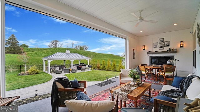 view of patio with a gazebo, an outdoor hangout area, a fenced backyard, outdoor dining area, and a ceiling fan