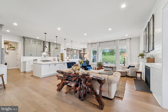 living area with recessed lighting, light wood finished floors, and a fireplace