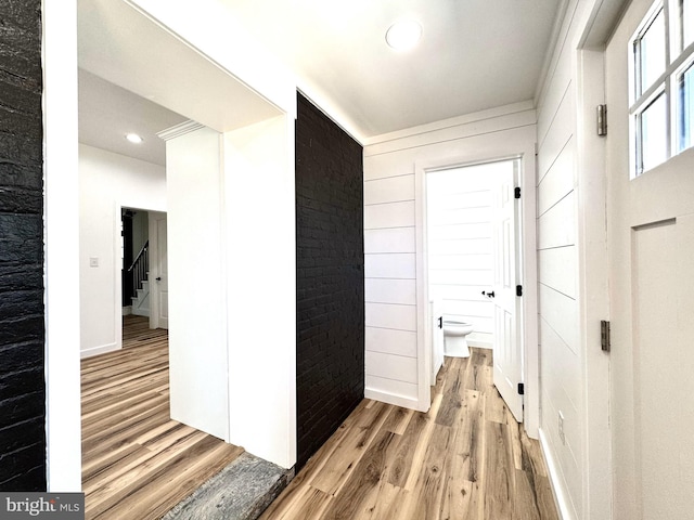 hall featuring recessed lighting, baseboards, light wood-type flooring, and stairs