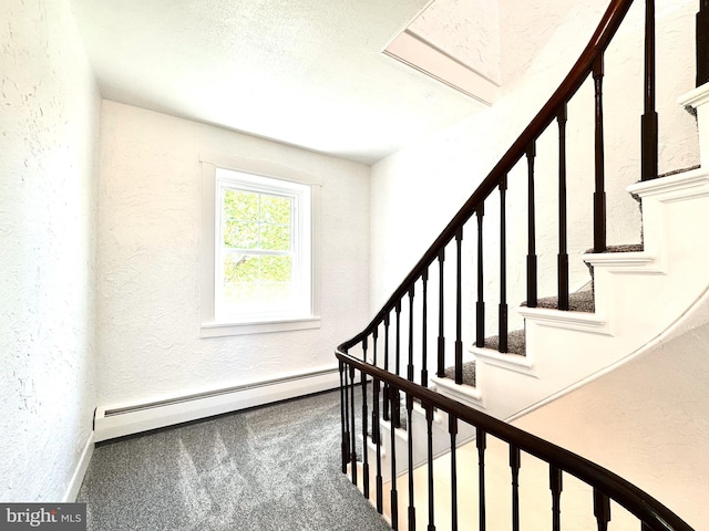 stairs with carpet floors, a textured wall, baseboards, and a baseboard heating unit