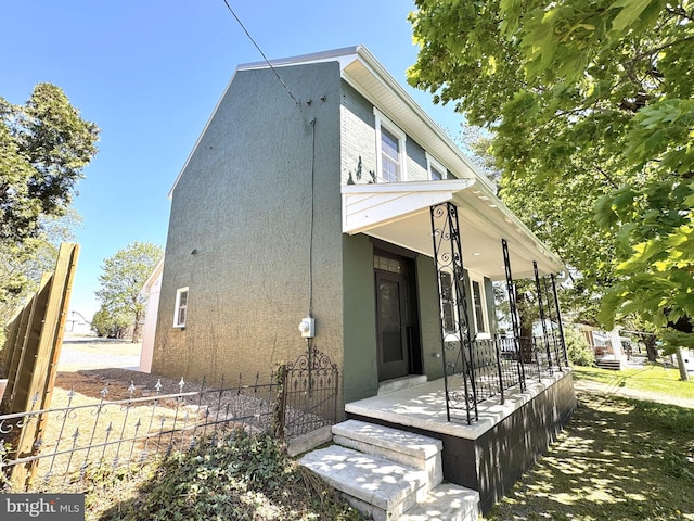 exterior space with stucco siding and fence