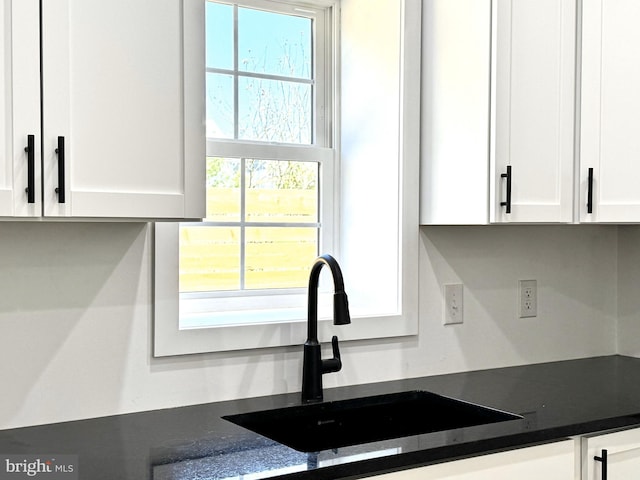 kitchen featuring a sink and white cabinetry