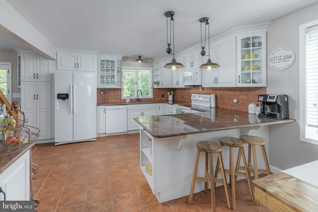 kitchen with tasteful backsplash, open shelves, a sink, a peninsula, and white appliances