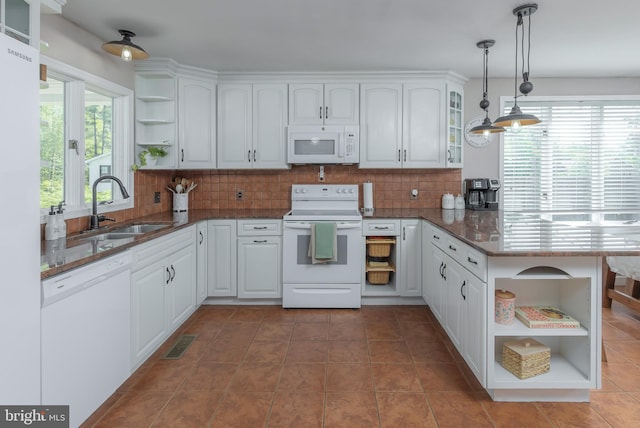 kitchen featuring visible vents, open shelves, a peninsula, white appliances, and a sink