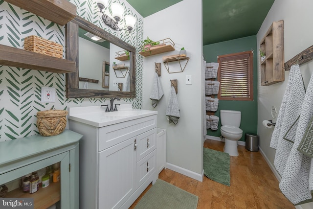 bathroom featuring vanity, baseboards, toilet, and wood finished floors
