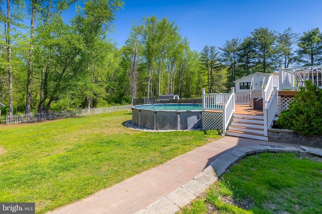 view of yard featuring an outdoor pool, a wooden deck, stairway, and fence