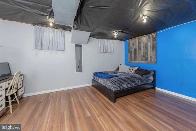 bedroom with baseboards and wood finished floors