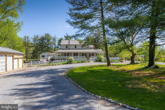 farmhouse featuring fence, a front yard, metal roof, a porch, and driveway