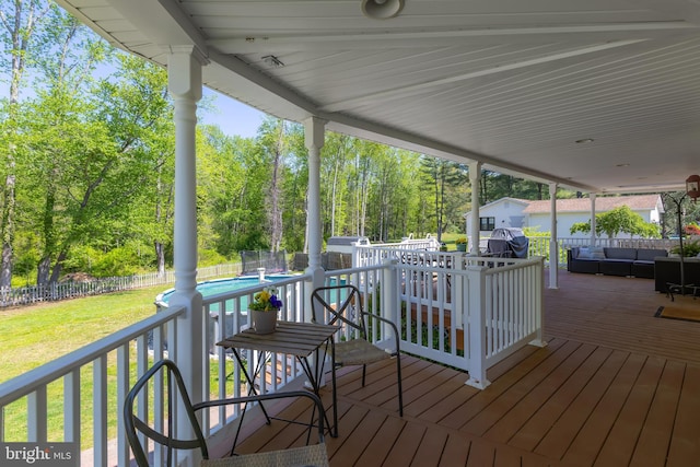 wooden terrace with a storage shed, a fenced in pool, an outdoor hangout area, a fenced backyard, and a yard