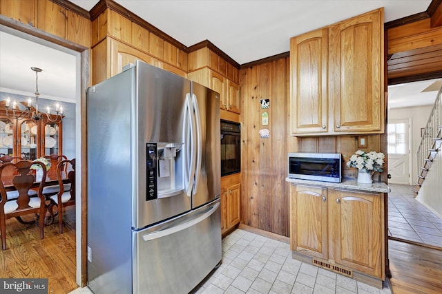 122 Tregarone Rd, Lutherville Timonium, MD 21093 - kitchen featuring wooden walls, crown molding, a notable chandelier, stainless steel appliances, and visible vents