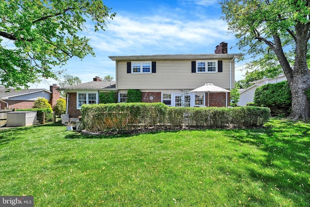 122 Tregarone Rd, Lutherville Timonium, MD 21093 - view of front of house featuring brick siding, a front lawn, and a chimney