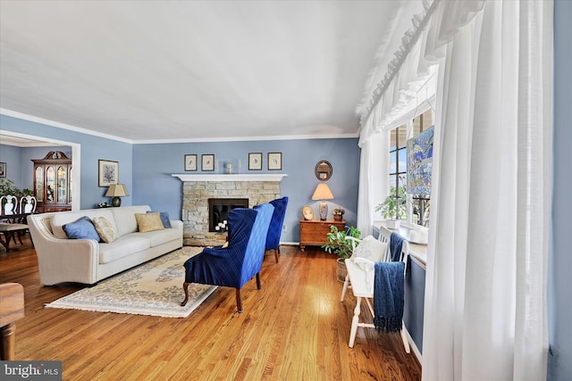 122 Tregarone Rd, Lutherville Timonium, MD 21093 - living room featuring a stone fireplace, ornamental molding, baseboards, and wood finished floors
