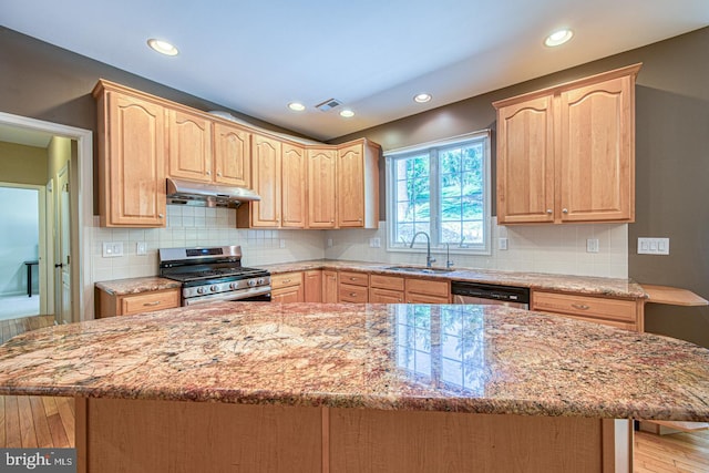 kitchen with a sink, appliances with stainless steel finishes, light brown cabinets, and under cabinet range hood