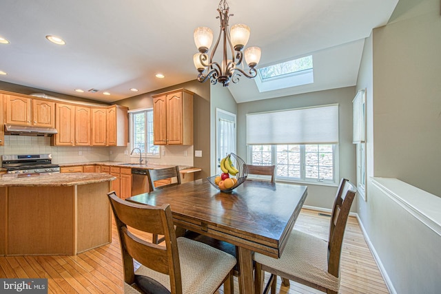 dining room with recessed lighting, light wood finished floors, baseboards, and vaulted ceiling with skylight
