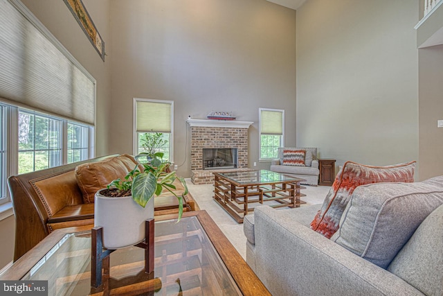 living room with plenty of natural light, a high ceiling, and a fireplace