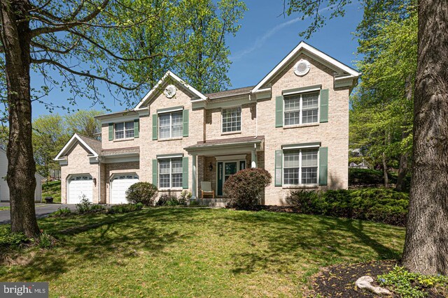 view of front facade with brick siding, a garage, aphalt driveway, and a front yard
