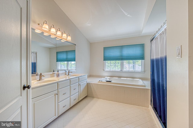 full bathroom featuring double vanity, a sink, and a wealth of natural light