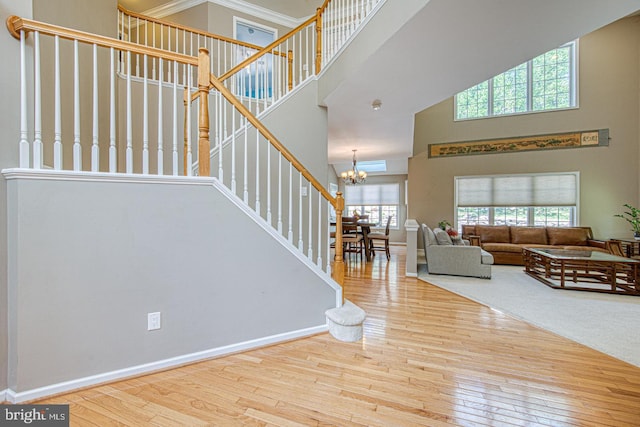 living room featuring a high ceiling, a chandelier, stairway, and hardwood / wood-style flooring