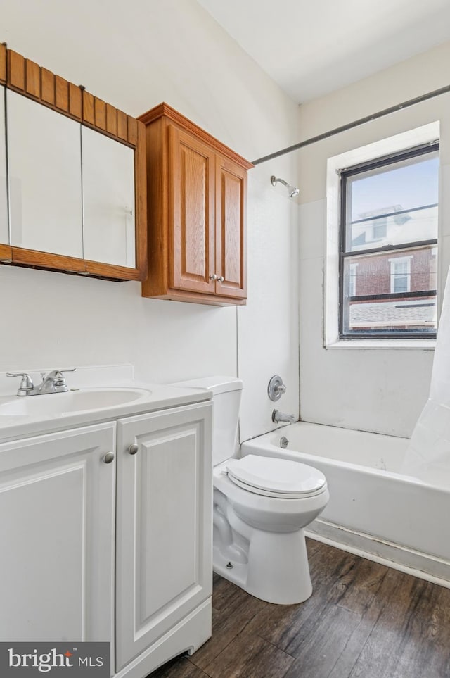 bathroom featuring toilet, shower / tub combination, wood finished floors, and vanity