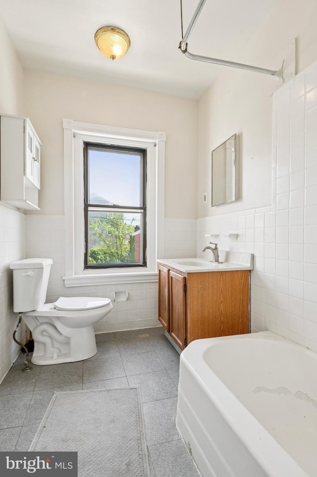 bathroom featuring toilet, tile walls, and wainscoting