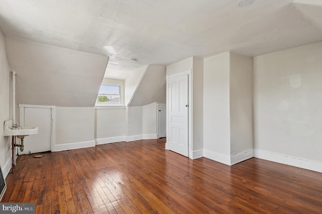 bonus room featuring baseboards, lofted ceiling, and hardwood / wood-style floors