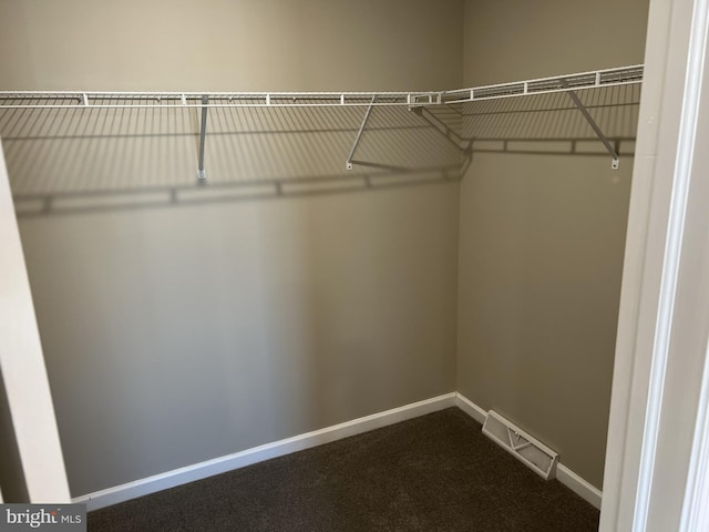 walk in closet featuring visible vents and dark colored carpet