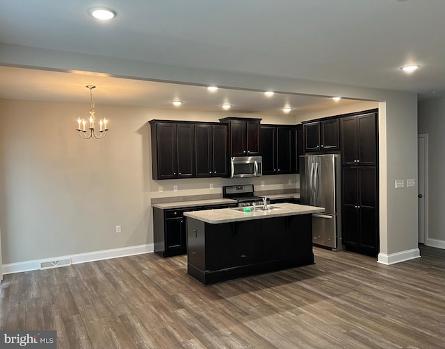 kitchen with an inviting chandelier, appliances with stainless steel finishes, baseboards, and visible vents