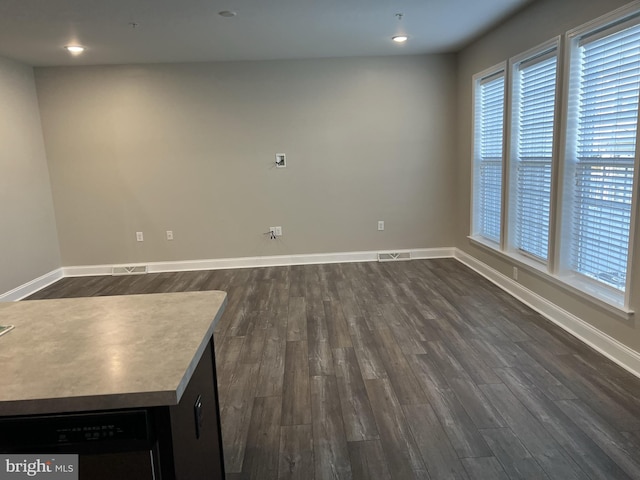 interior space with a healthy amount of sunlight, dark wood-style floors, and visible vents